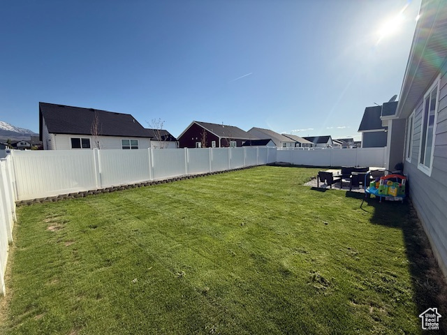 View of yard featuring a patio, a fenced backyard, and a residential view
