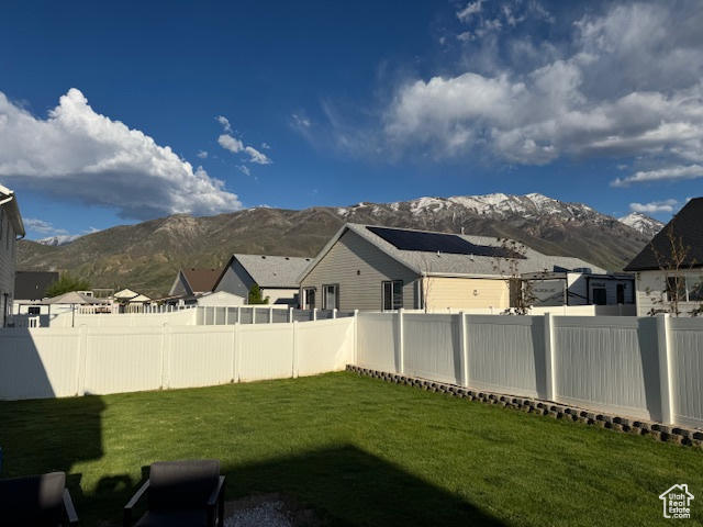 View of yard with a fenced backyard, a mountain view, and a residential view