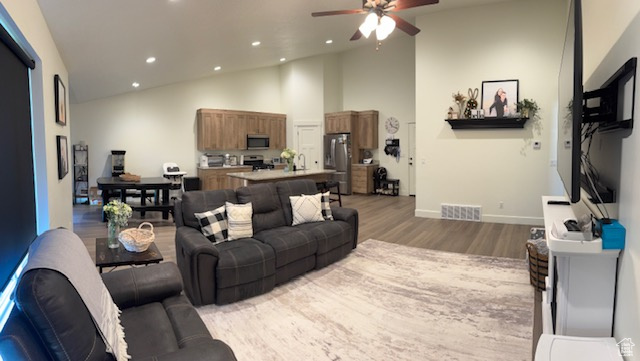 Living area with a ceiling fan, visible vents, wood finished floors, baseboards, and recessed lighting