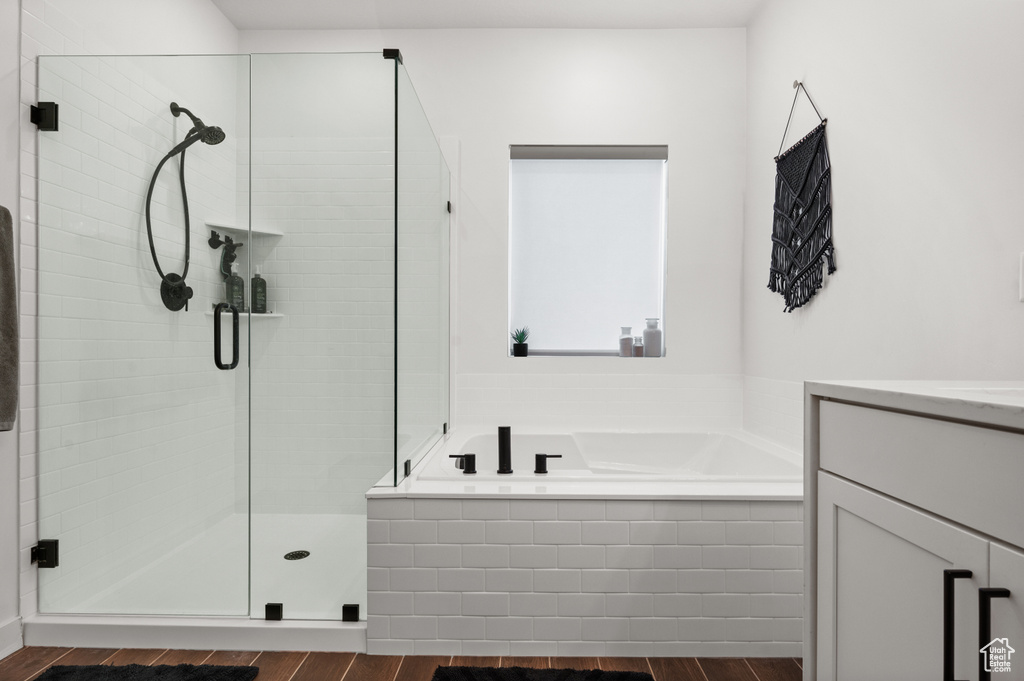 Bathroom featuring a bath, vanity, wood finished floors, and a shower stall