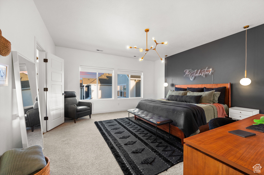 Bedroom featuring light carpet and a notable chandelier