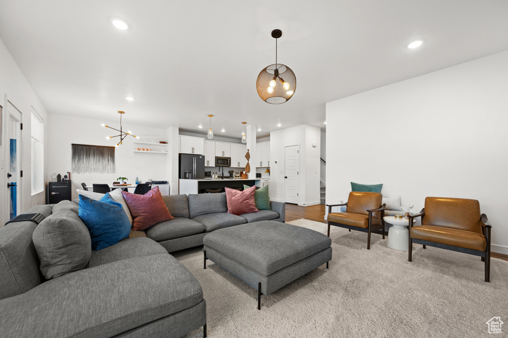 Living room featuring an inviting chandelier, baseboards, and recessed lighting