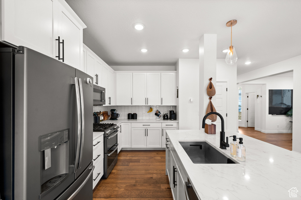 Kitchen featuring a sink, stainless steel appliances, recessed lighting, dark wood-style flooring, and white cabinetry