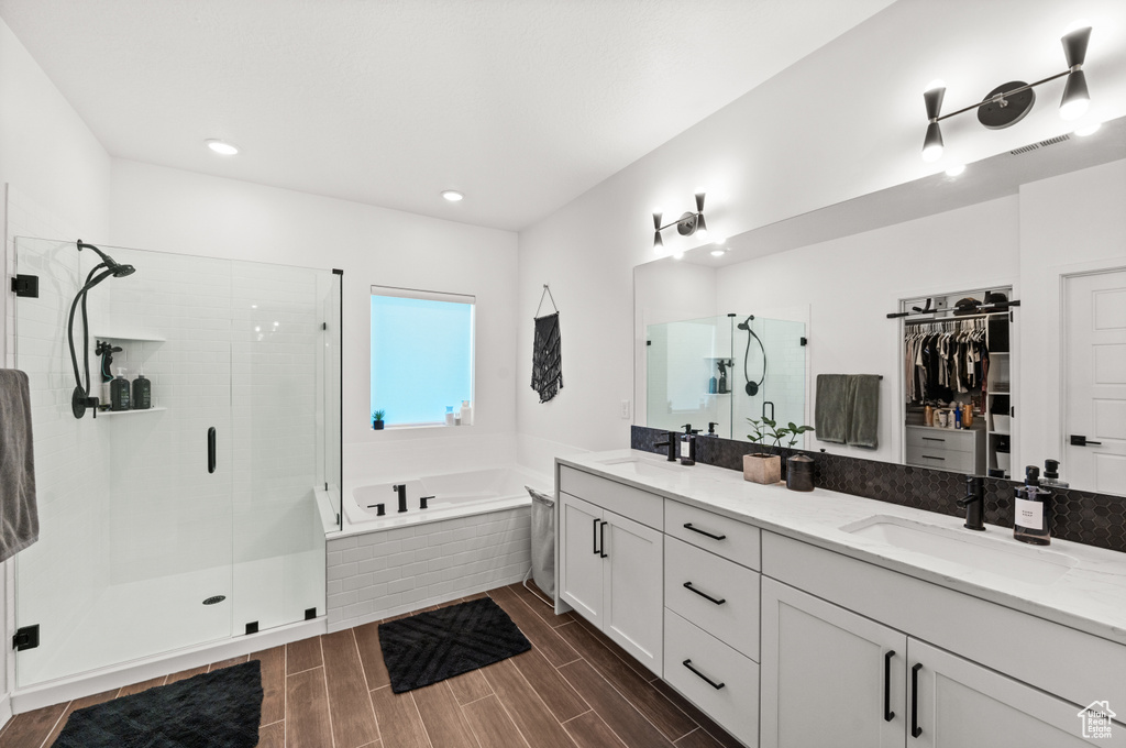 Full bath featuring a sink, visible vents, a shower stall, double vanity, and a bath