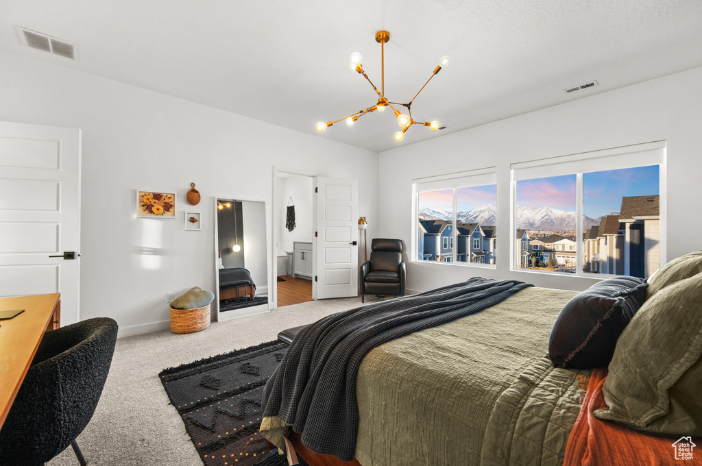Carpeted bedroom with a chandelier, baseboards, and visible vents