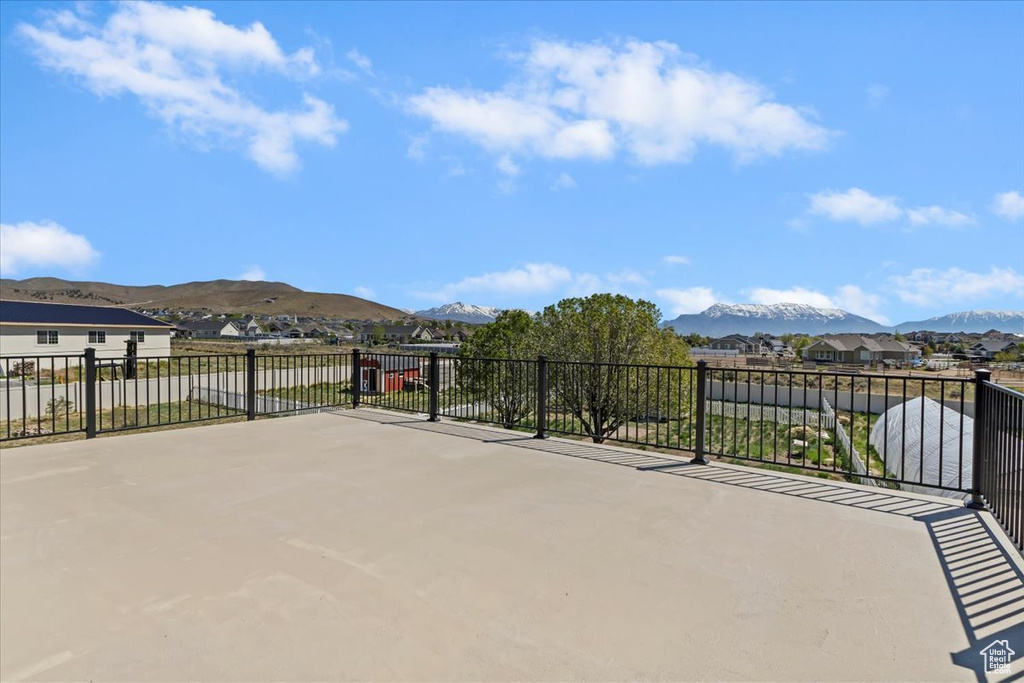 View of patio with a mountain view and fence