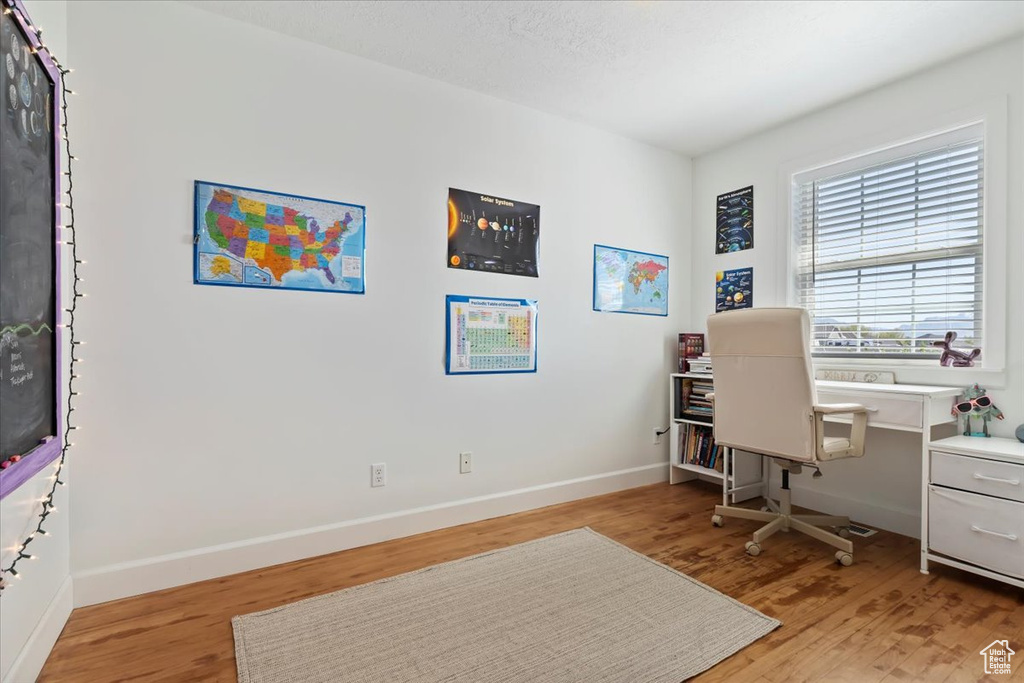 Office with baseboards and light wood-type flooring