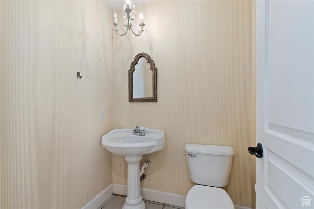Half bath featuring tile patterned floors, toilet, and baseboards