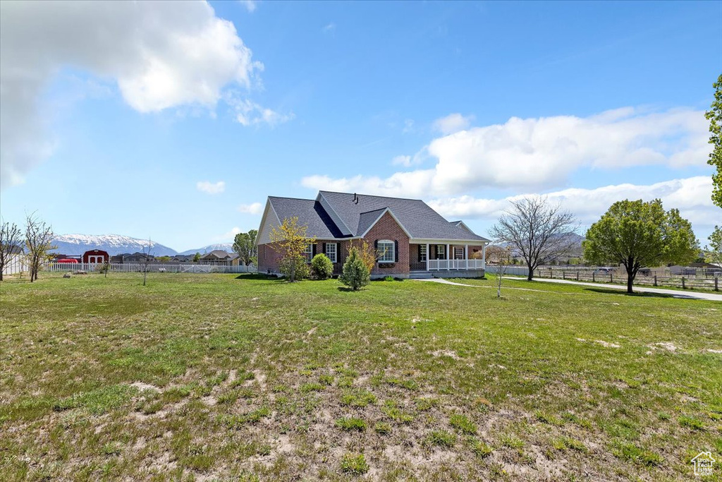View of front of home with brick siding, fence, and a front yard