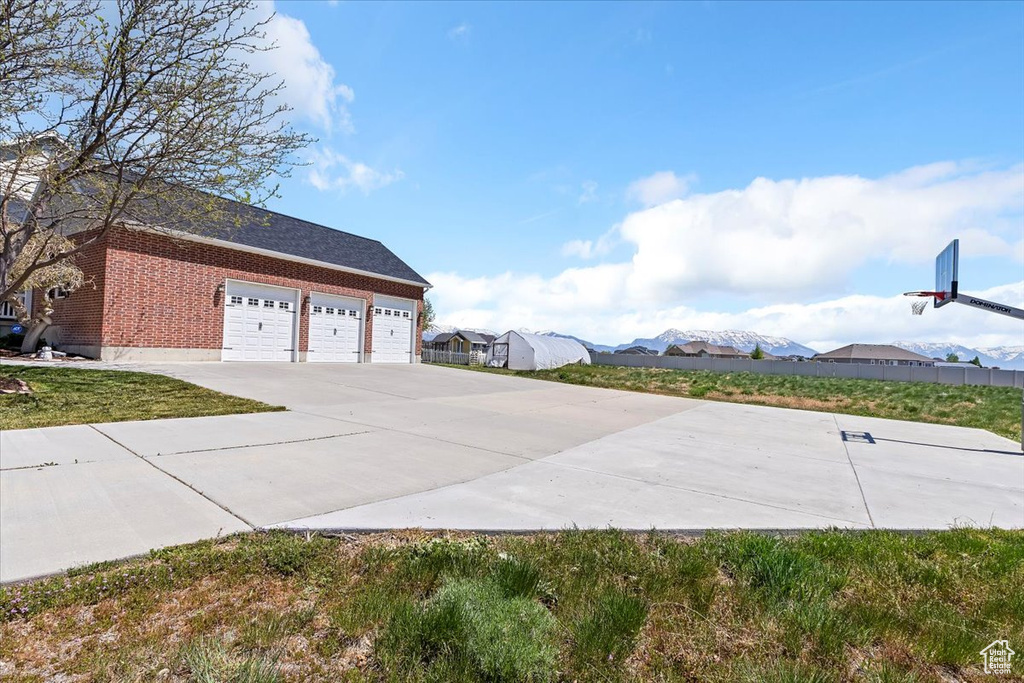 View of side of home with concrete driveway, brick siding, and a garage