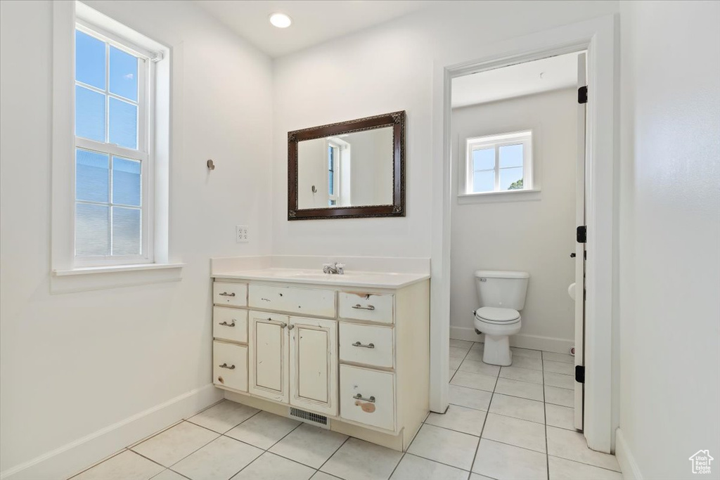 Bathroom with baseboards, tile patterned flooring, vanity, and toilet