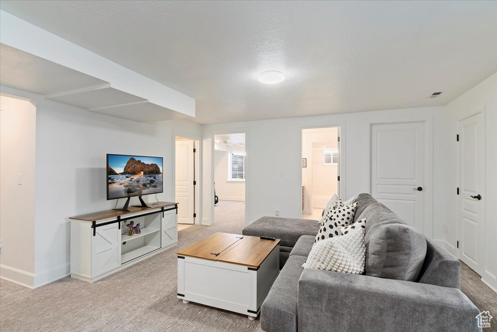 Living room with light colored carpet, visible vents, and baseboards