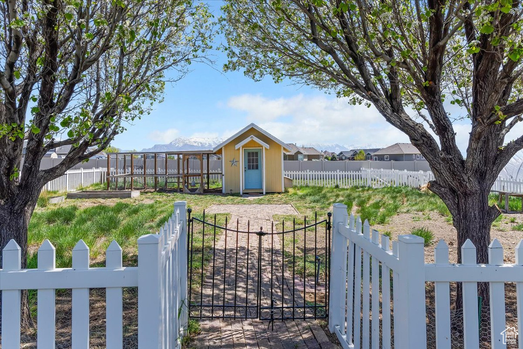 View of yard with a storage shed, a fenced front yard, an outbuilding, and a gate