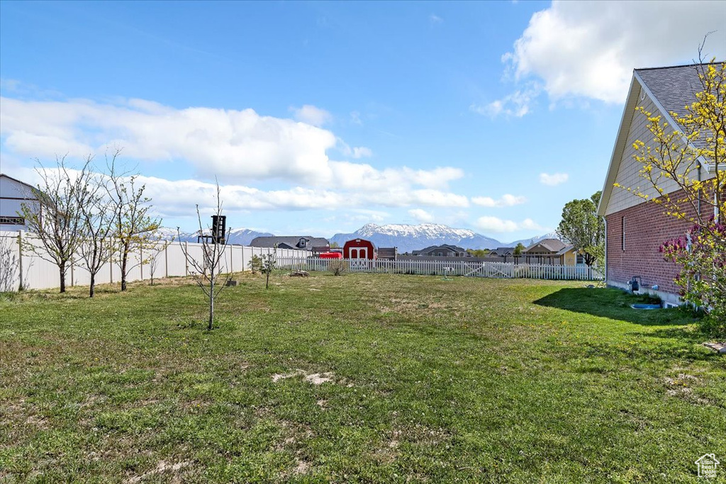 View of yard with a mountain view and fence