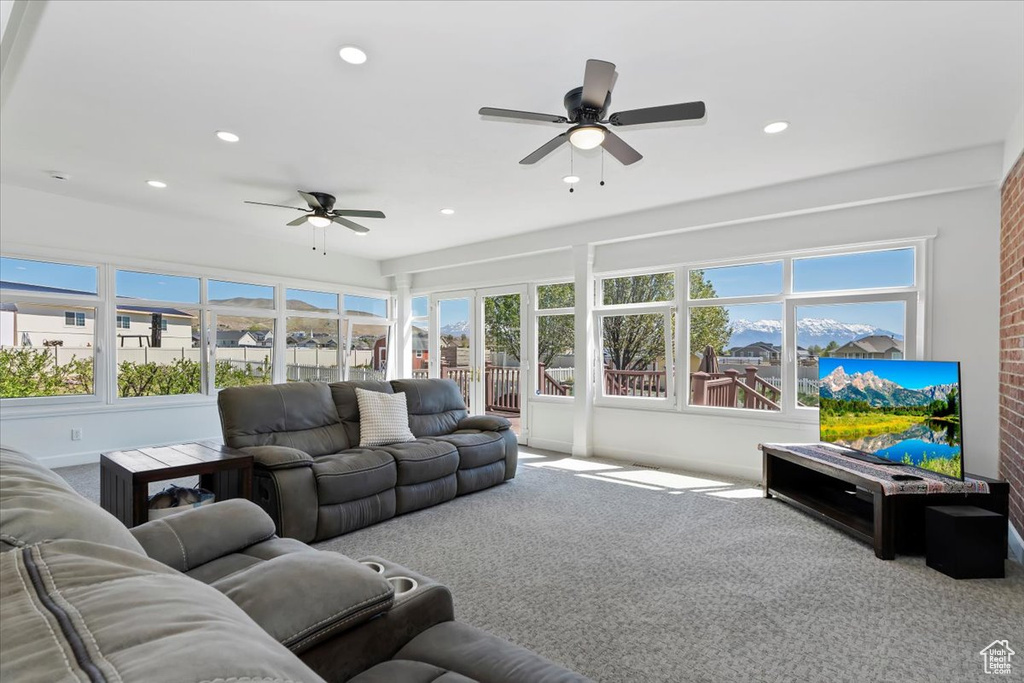 Carpeted living area with ceiling fan and recessed lighting