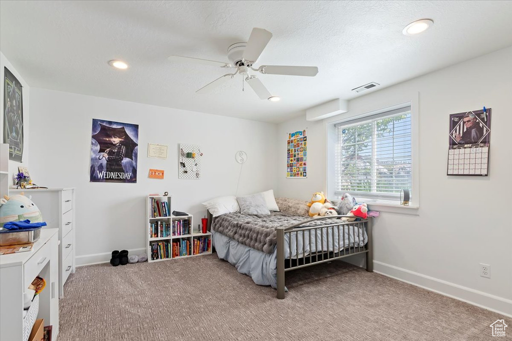 Carpeted bedroom with visible vents, baseboards, ceiling fan, and recessed lighting