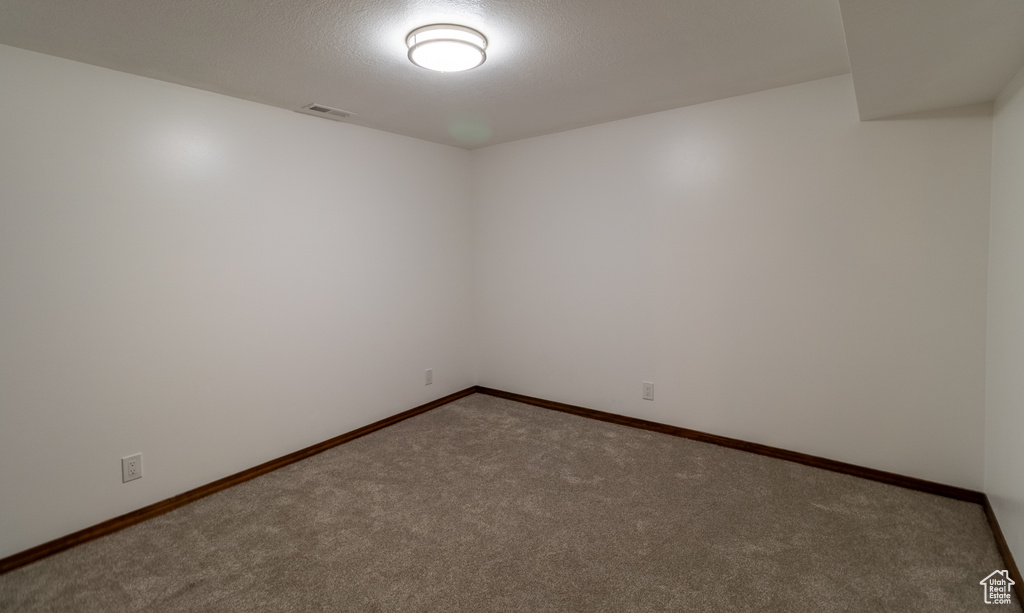 Spare room featuring carpet flooring, baseboards, and visible vents