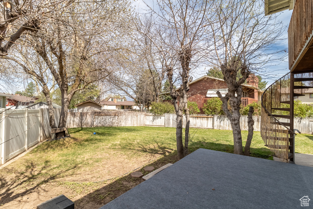 View of yard with a patio area, a fenced backyard, and stairs
