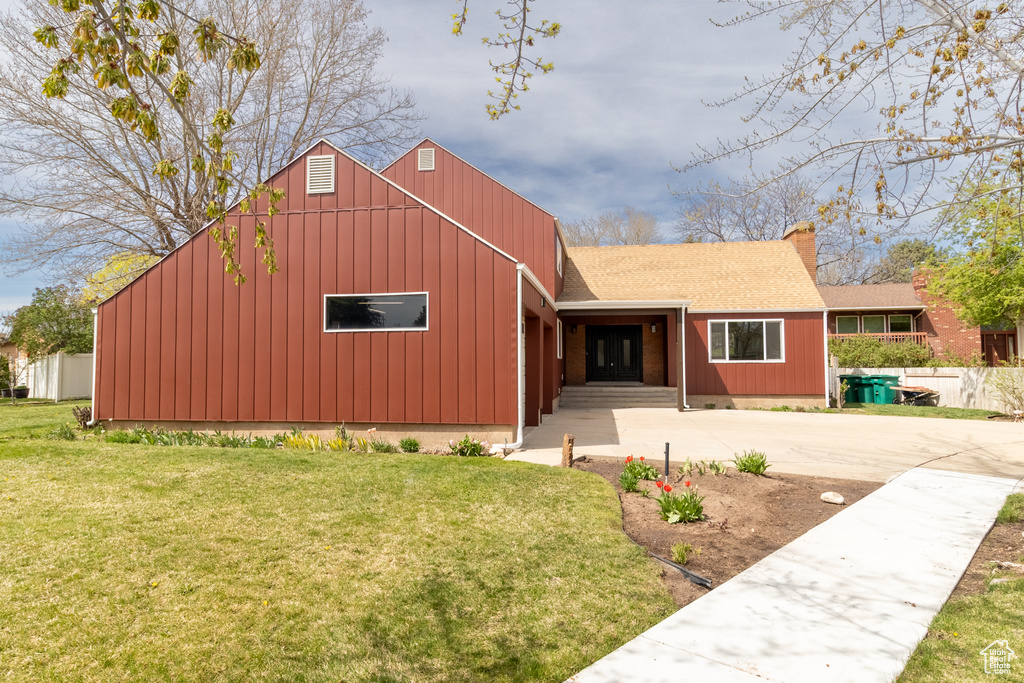 View of front of property with a front yard and driveway