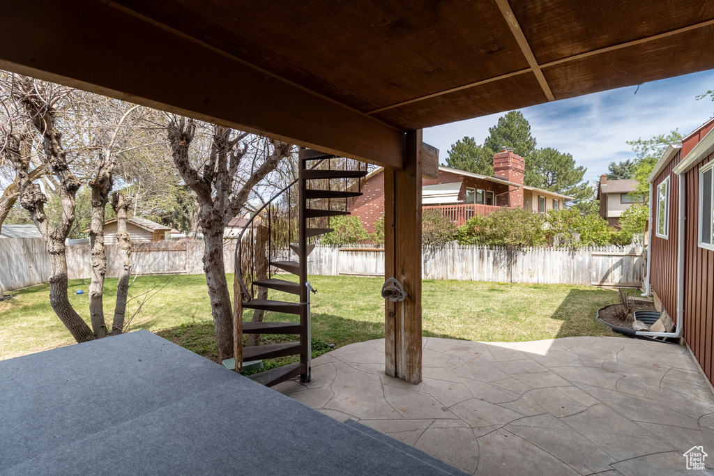 View of patio with a fenced backyard and stairs