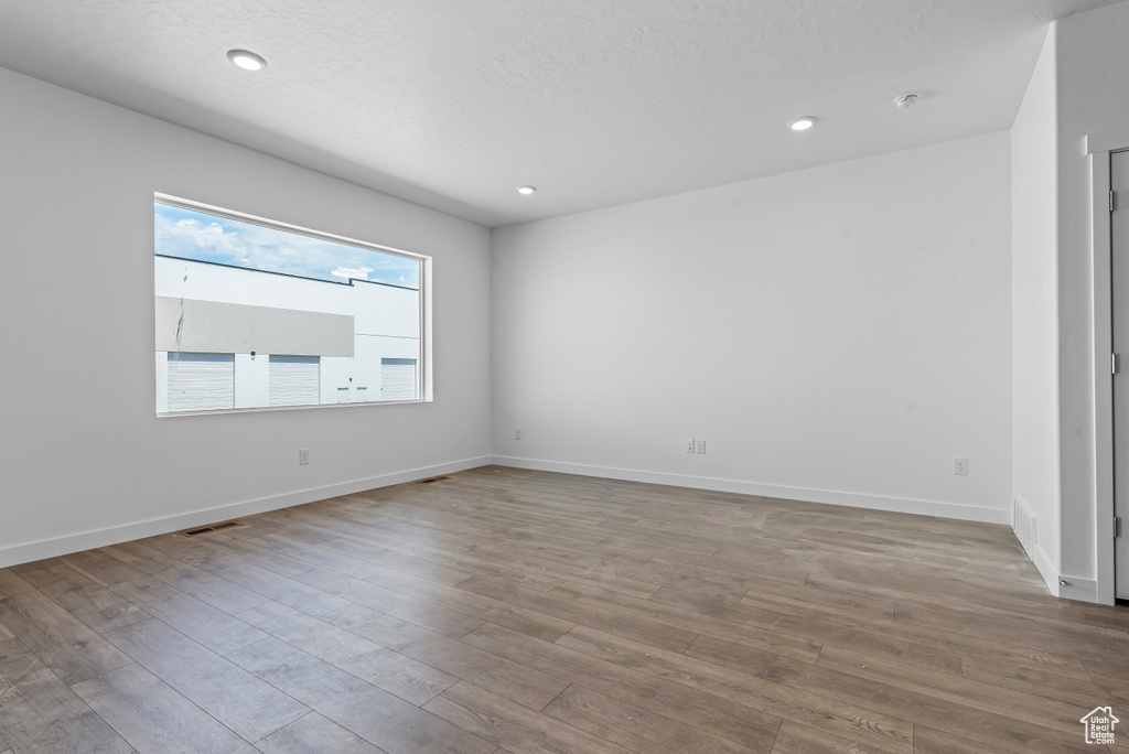 Spare room with baseboards, visible vents, and wood finished floors
