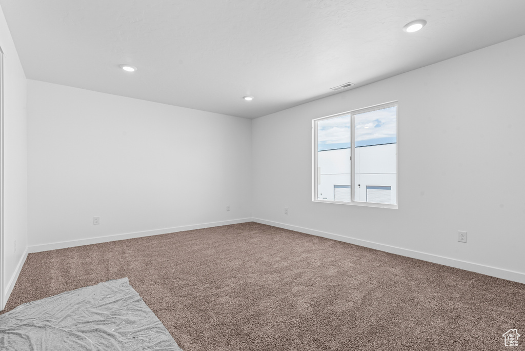 Empty room with baseboards, carpet flooring, and visible vents