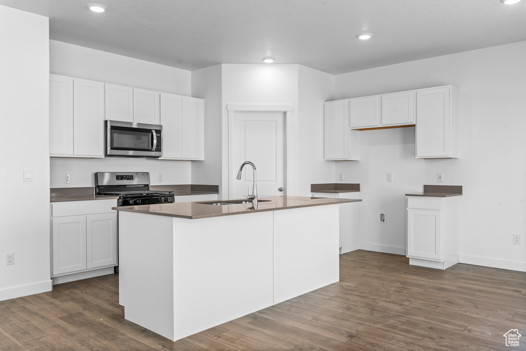 Kitchen featuring a sink, stainless steel appliances, a kitchen island with sink, recessed lighting, and dark wood-style flooring