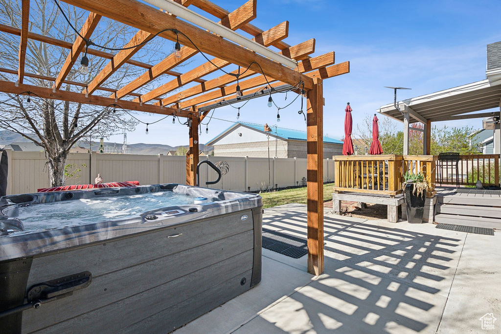 View of patio / terrace featuring a hot tub, a pergola, and a fenced backyard