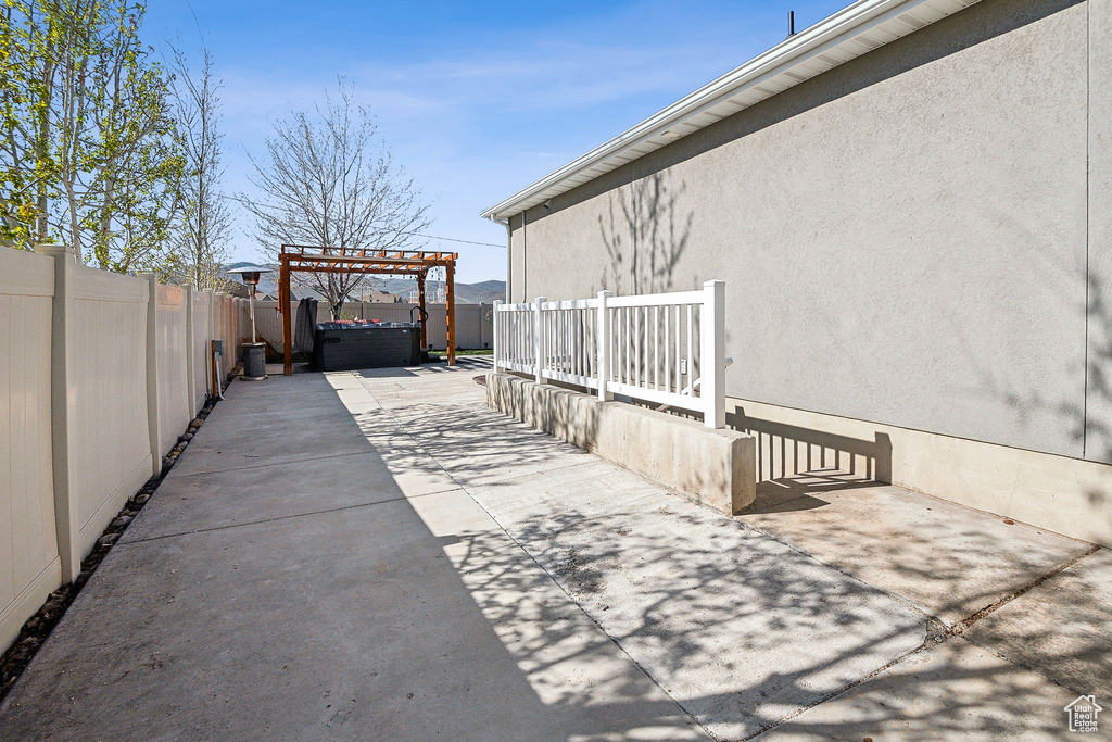 View of patio / terrace with a hot tub, a pergola, and a fenced backyard