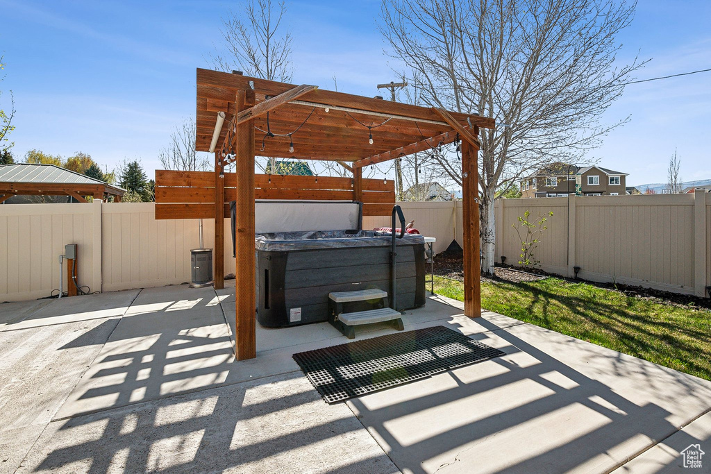 View of patio with a hot tub and a fenced backyard