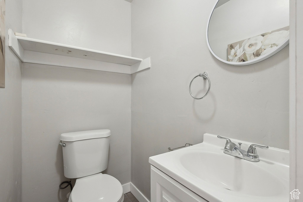 Bathroom with toilet, baseboards, and vanity