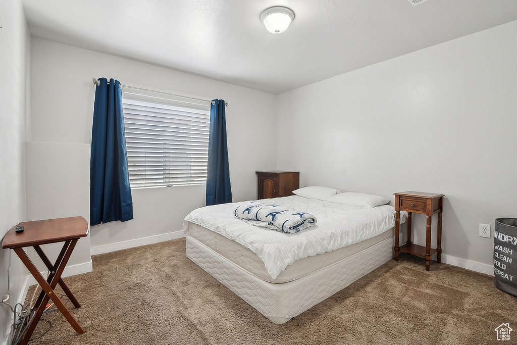 Bedroom featuring baseboards and carpet