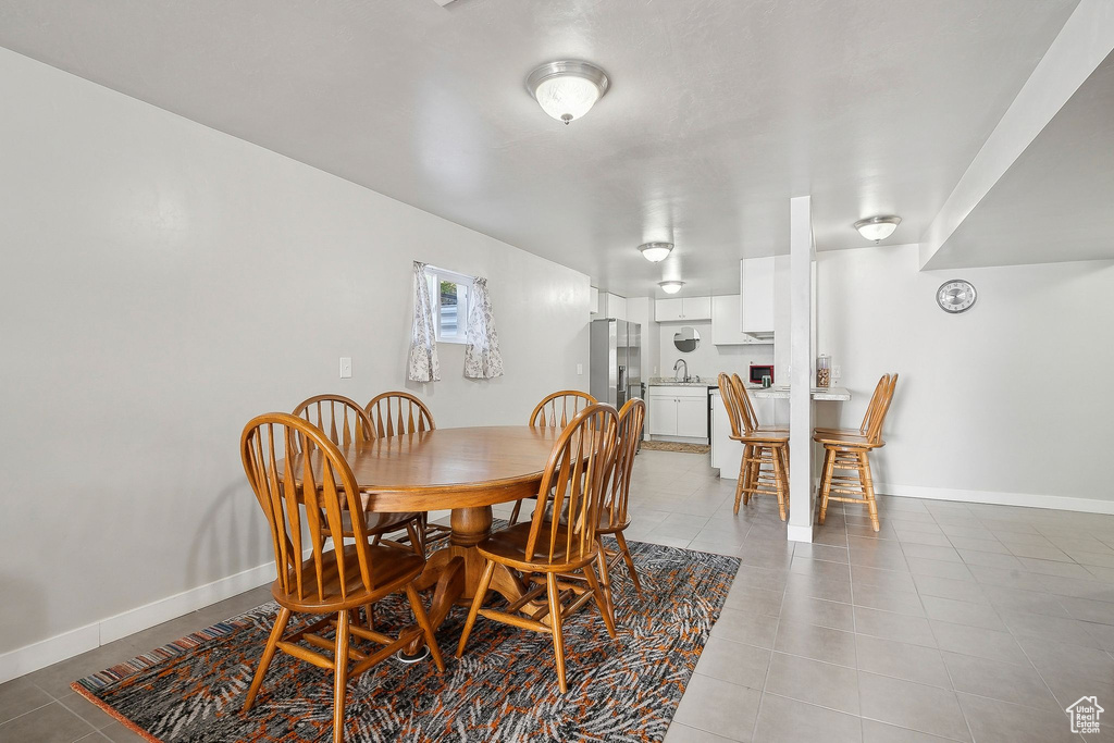 Dining room featuring light tile patterned floors and baseboards