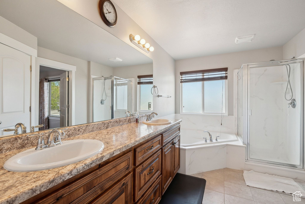 Bathroom with double vanity, a bath, a shower stall, and a sink