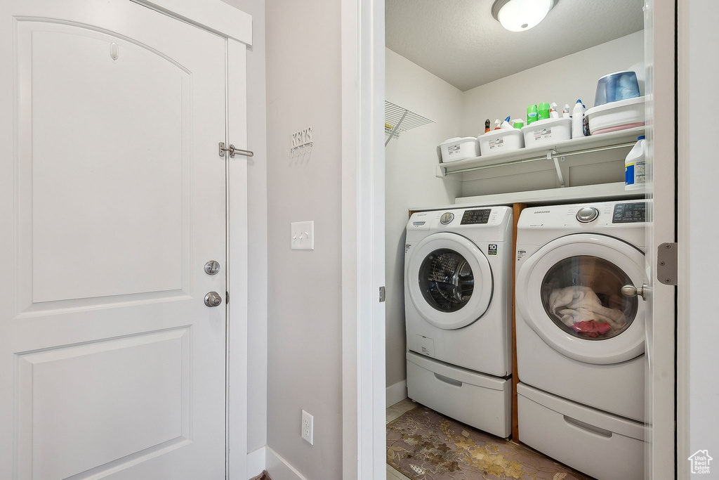 Clothes washing area featuring independent washer and dryer and baseboards