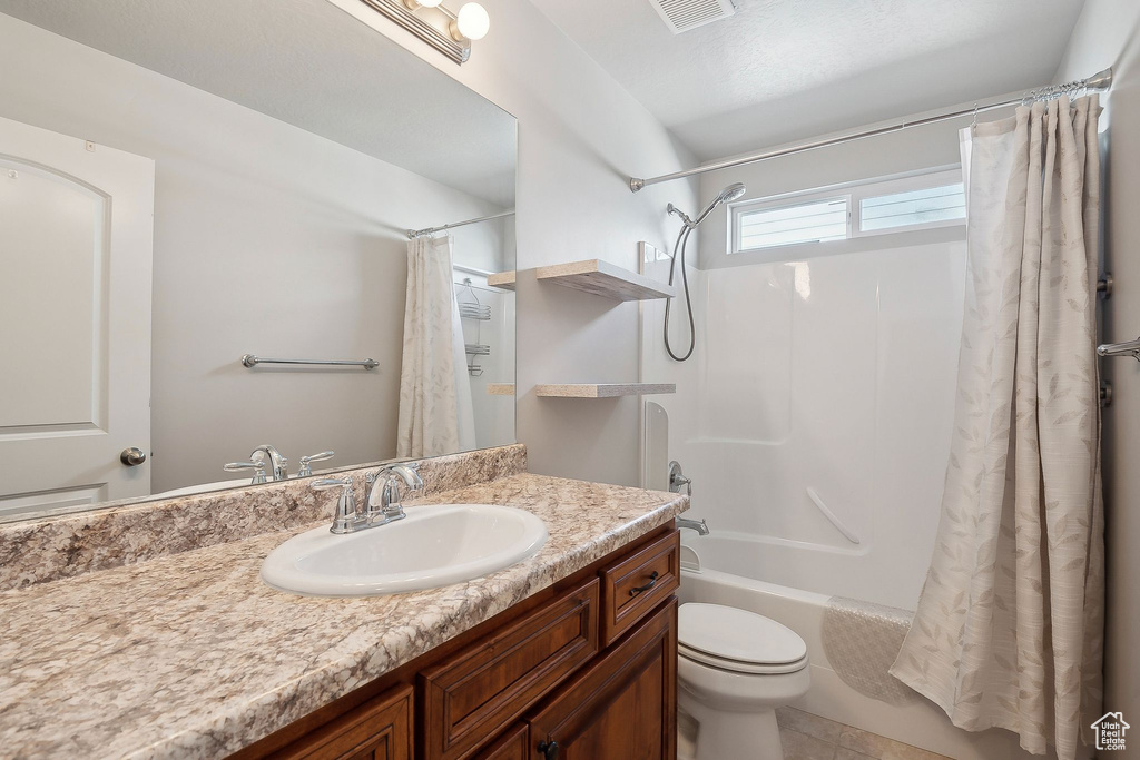 Bathroom featuring toilet, vanity, visible vents, tile patterned flooring, and shower / bathtub combination with curtain
