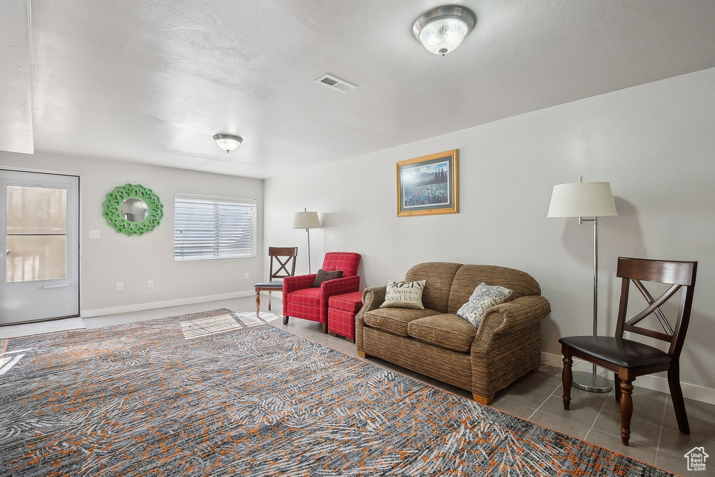 Living room with baseboards, visible vents, and tile patterned floors
