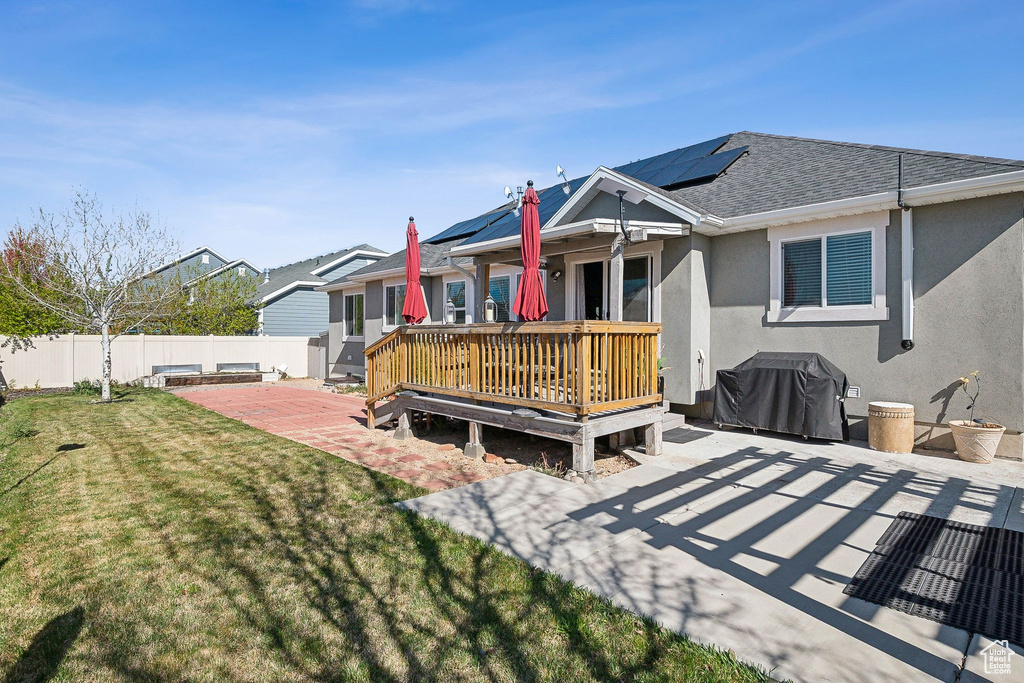 Rear view of property with a patio, stucco siding, a lawn, a fenced backyard, and roof with shingles