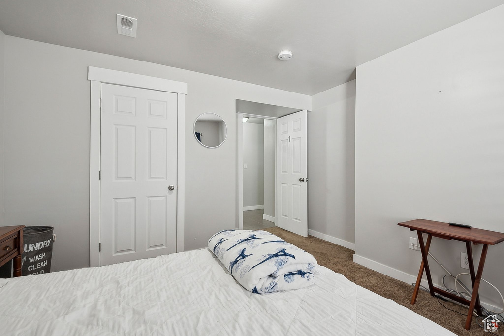 Carpeted bedroom with visible vents and baseboards