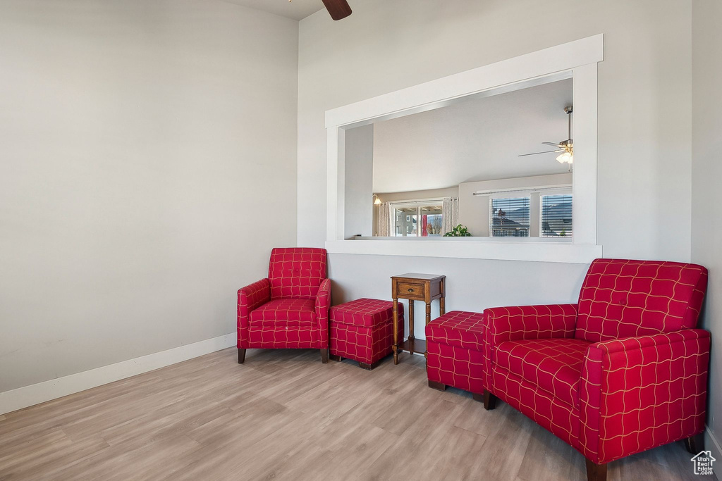Sitting room featuring baseboards, a ceiling fan, and wood finished floors