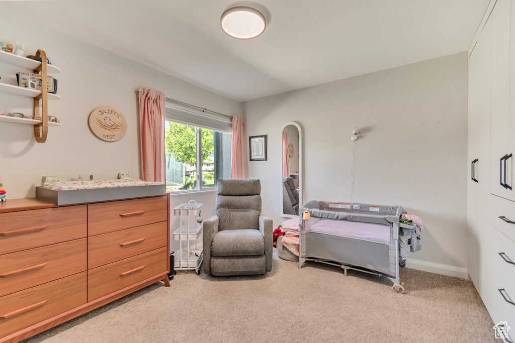Bedroom featuring light colored carpet and arched walkways