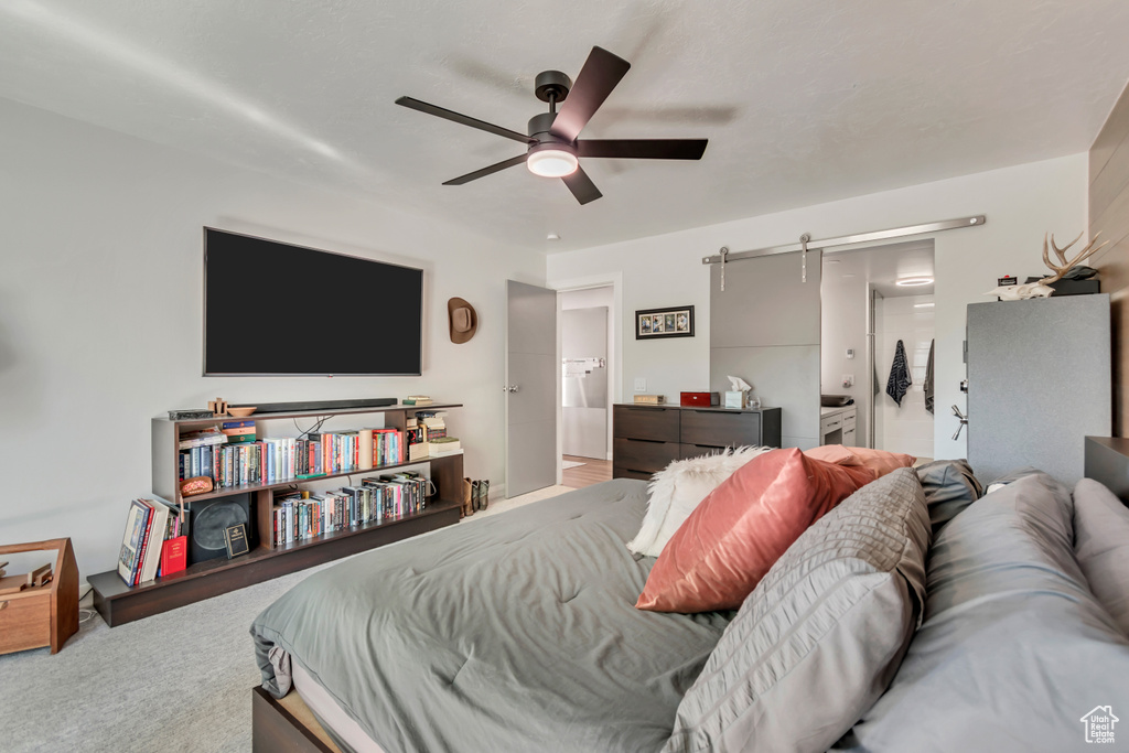 Bedroom featuring ceiling fan, carpet, and a barn door