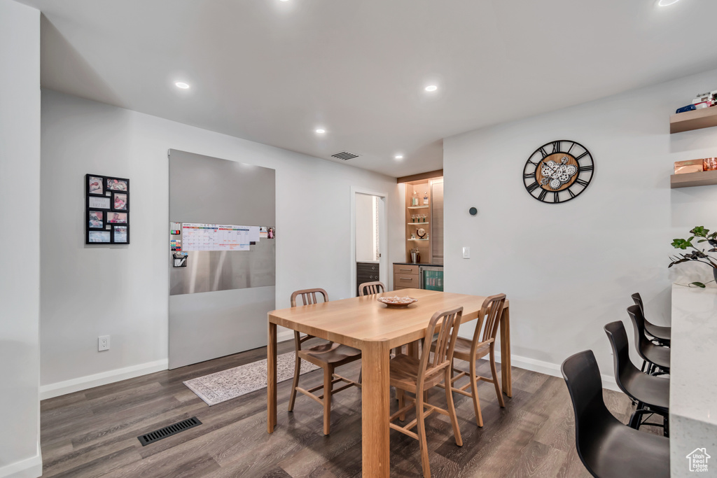 Dining room with visible vents, wood finished floors, and baseboards