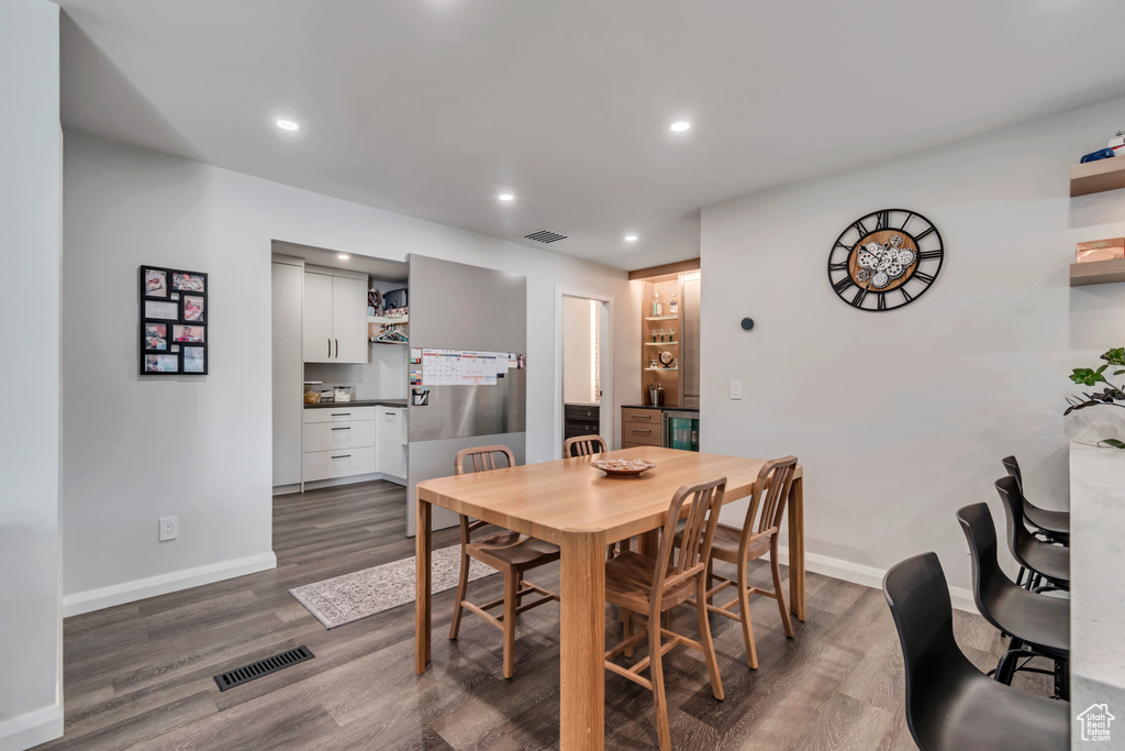 Dining space with baseboards, visible vents, and dark wood finished floors
