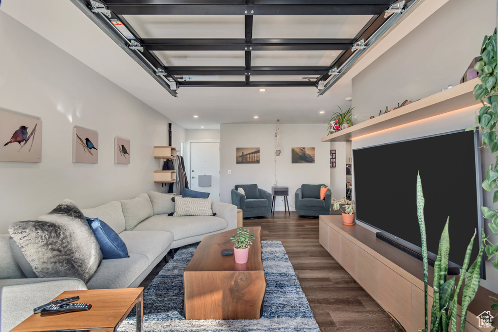Living area with dark wood-type flooring, a garage, and recessed lighting