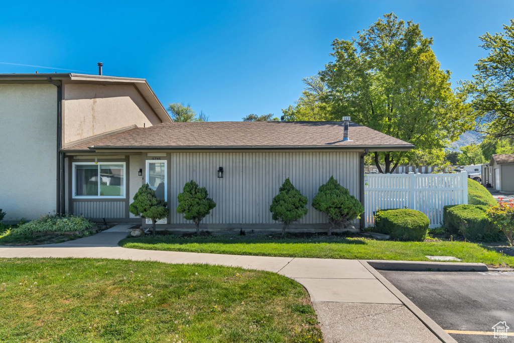 View of front of property with fence and a front lawn