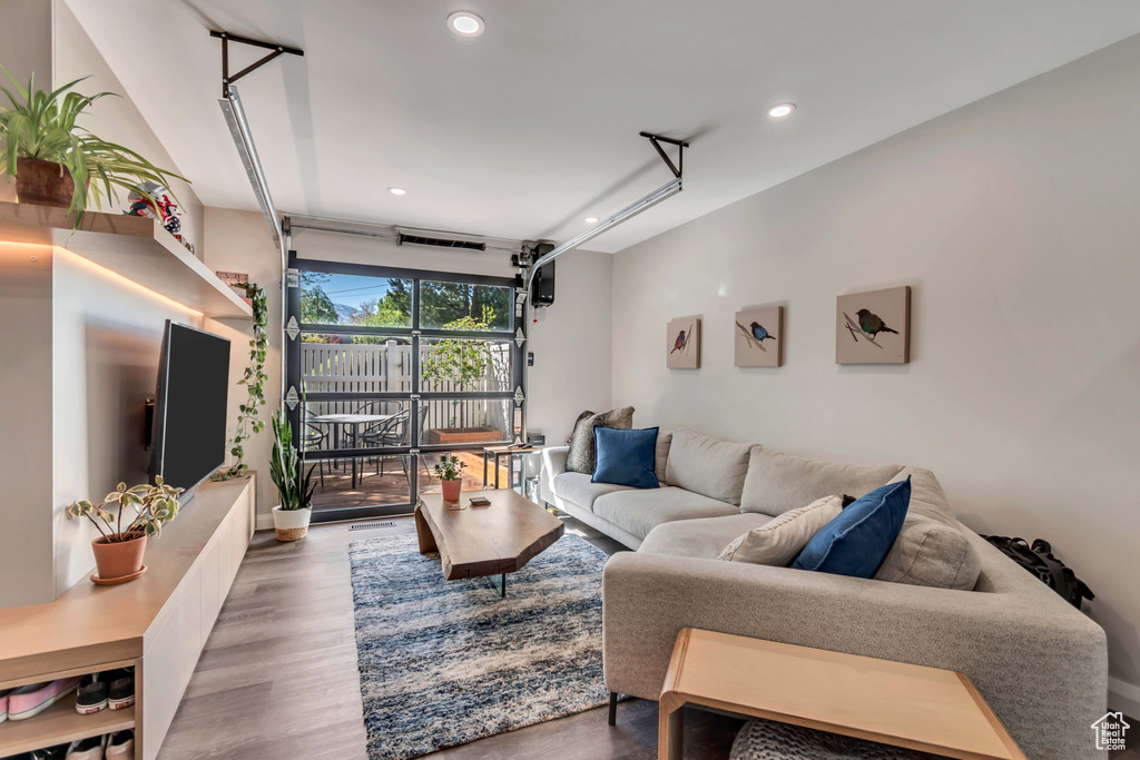 Living room with recessed lighting, a garage, and wood finished floors
