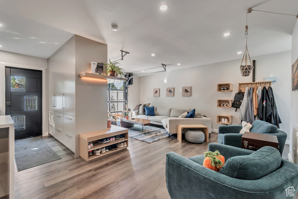 Living room with a wealth of natural light, light wood-style flooring, and recessed lighting
