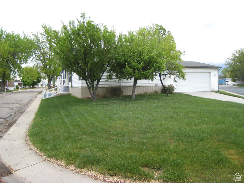 View of front facade with concrete driveway, a front yard, and a garage