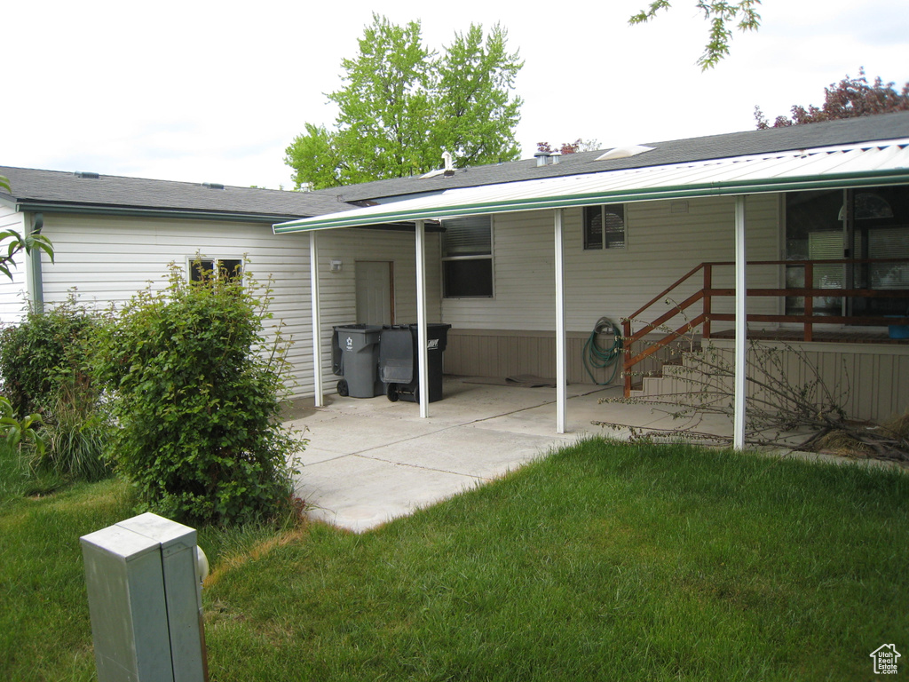 Back of house with a yard and a patio area